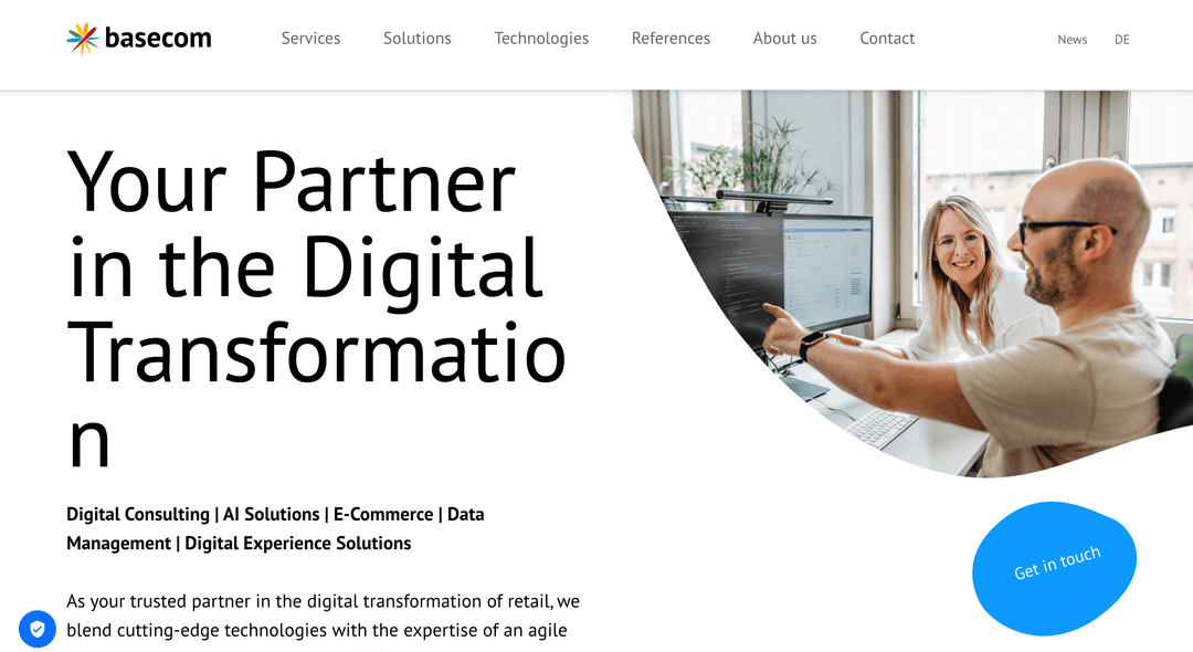Two colleagues collaborate at a computer in a bright office beside text about digital transformation services.