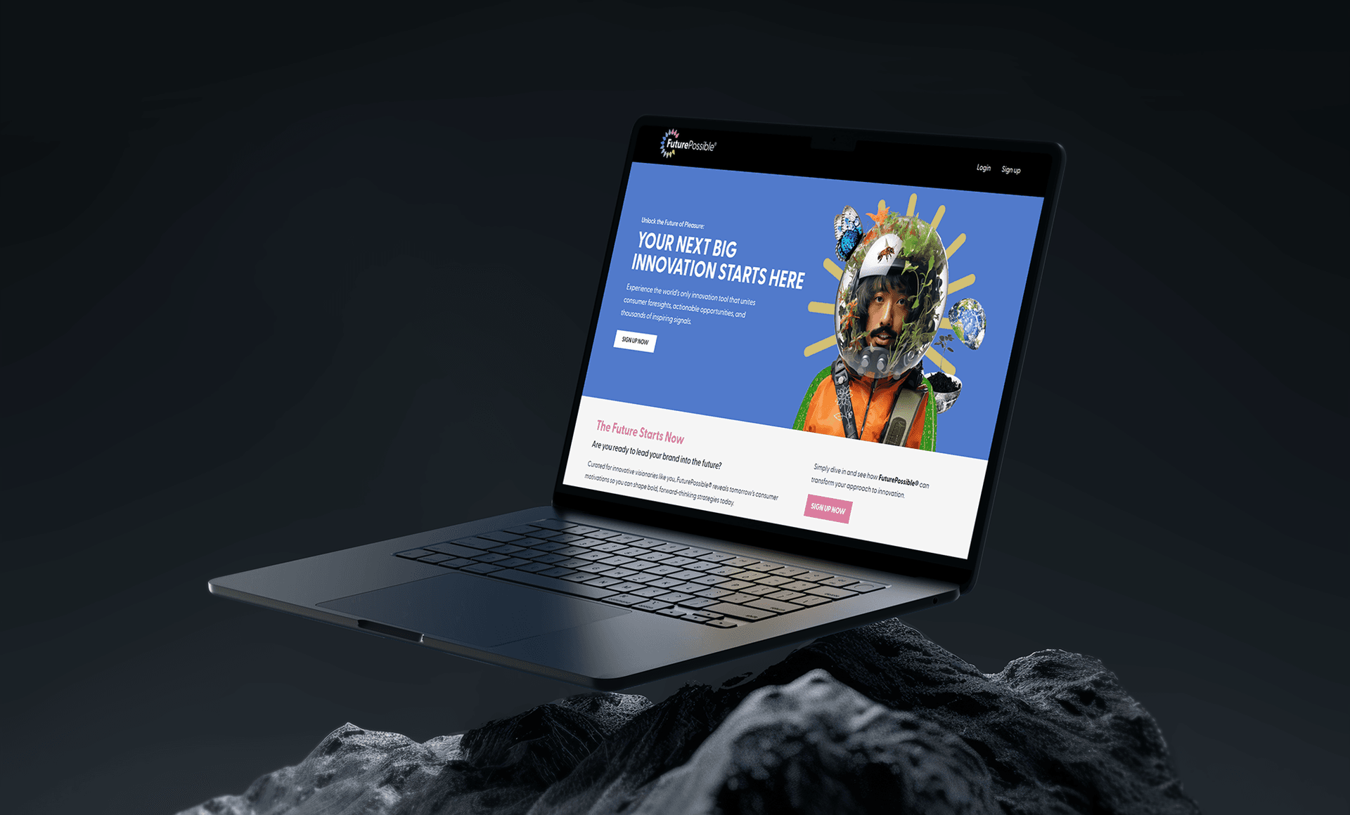 Laptop on dark rocky surface showing a creative agency website