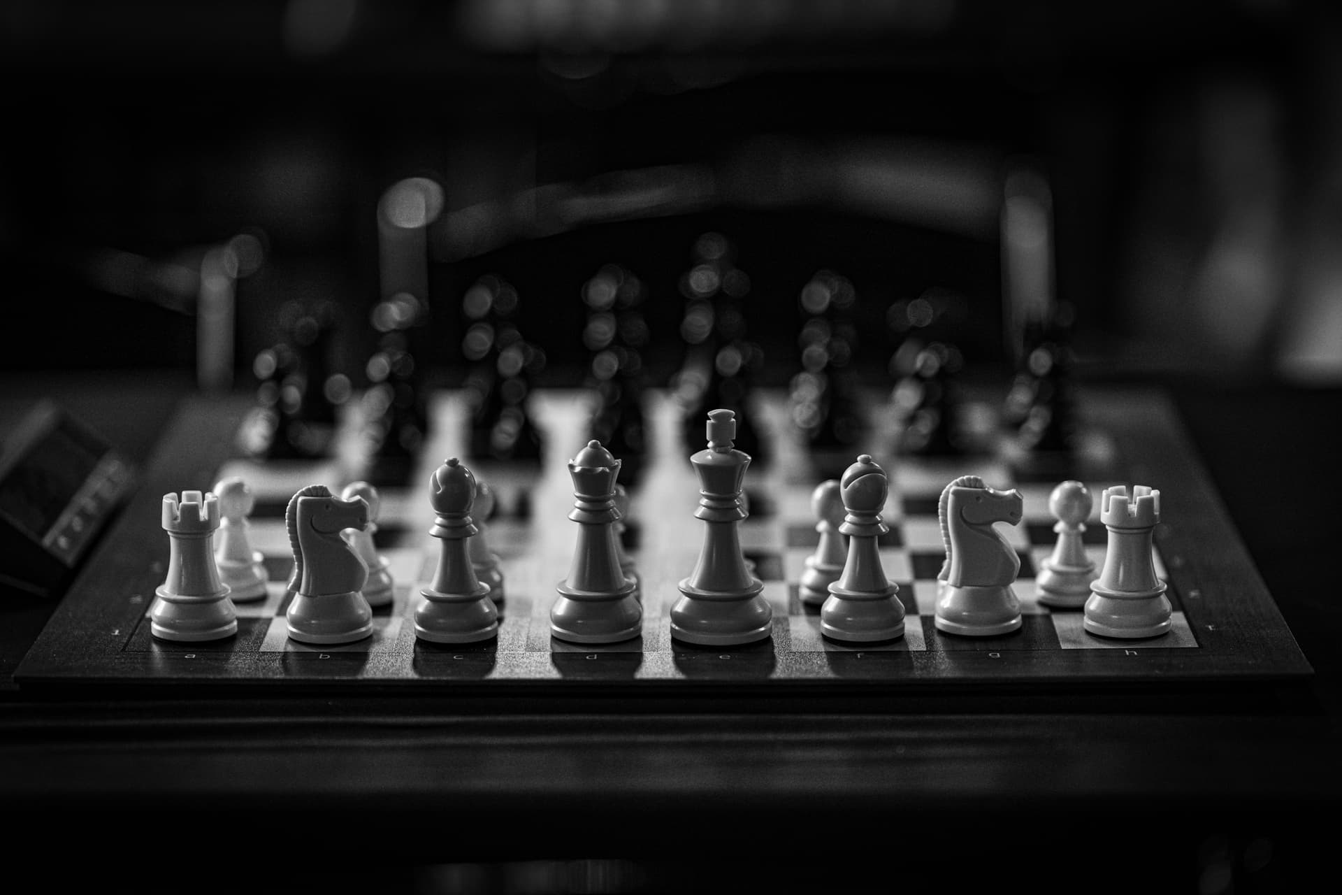 Black and white chess pieces arranged on a board mid-game