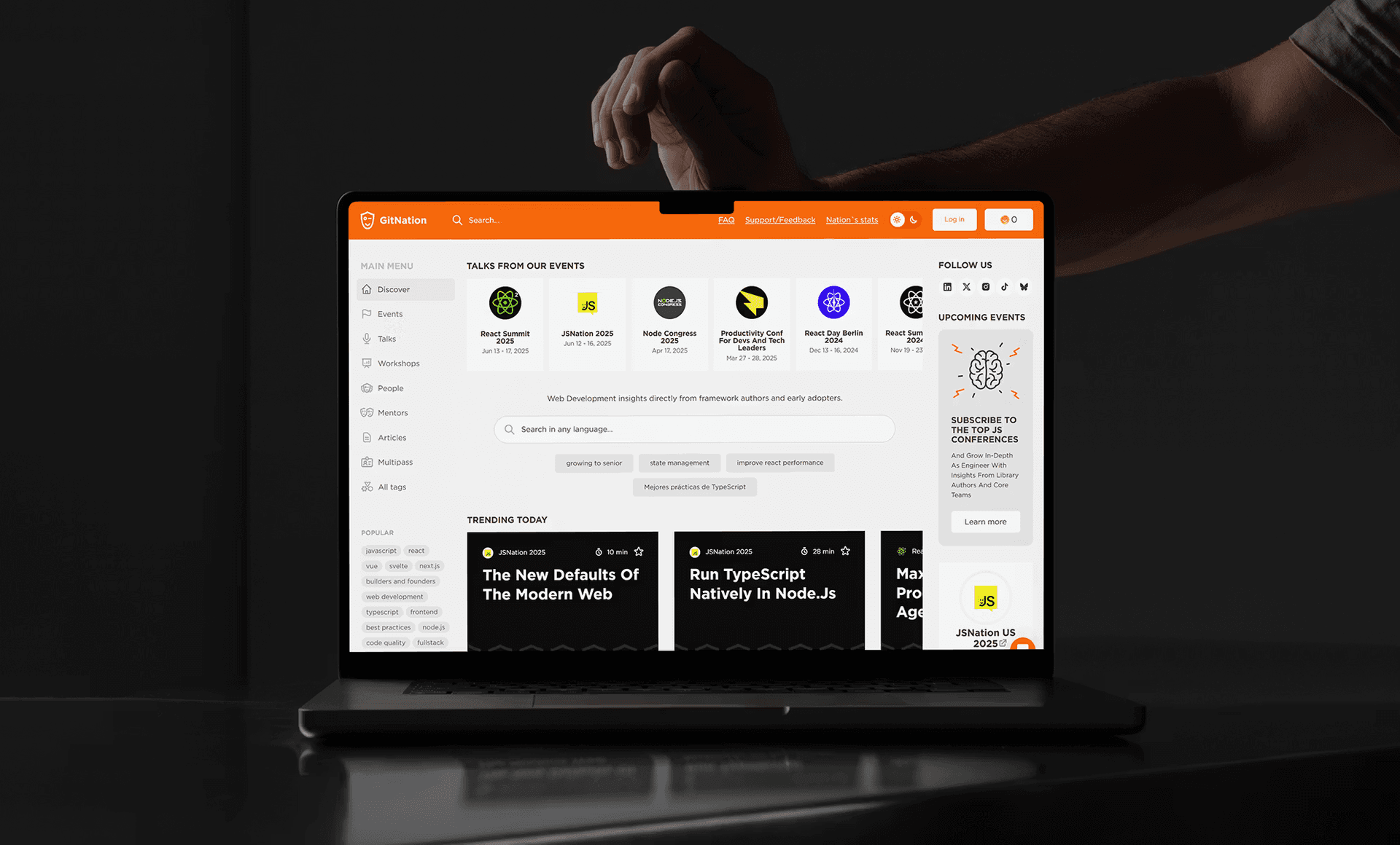 Laptop displaying Product Hunt-style website on dark background with orange accents