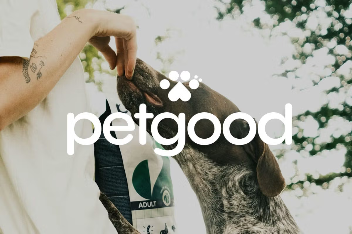 Petgood logo overlaid on photo of person feeding a dog outdoors